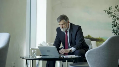 Businessman using laptop computer in office lobby or cafe. Stock Footage 250956219