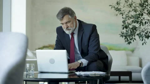 Businessman using laptop computer in office lobby or cafe. Stock Footage 250956936