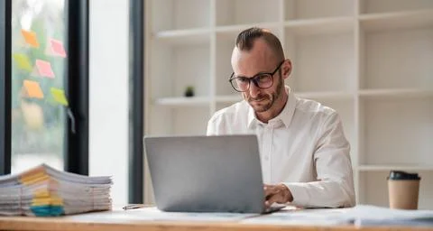 Businessman using laptop computer in office. Happy middle aged man, entrepreneur Stock Photos