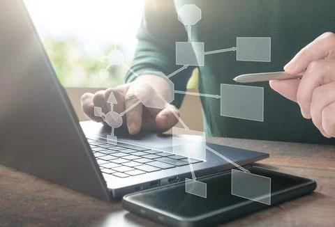 Businessman using laptop develops an interaction block diagram of algorithm i Stock Photos