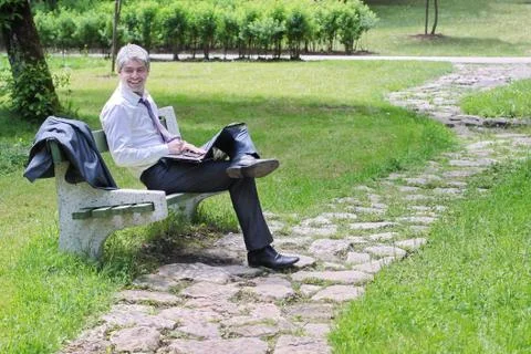 Businessman using laptop sitting on a bench Stock Photos