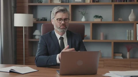 Businessman using a laptop talking to a camera making a conference business call Vídeos de archivo 220188744