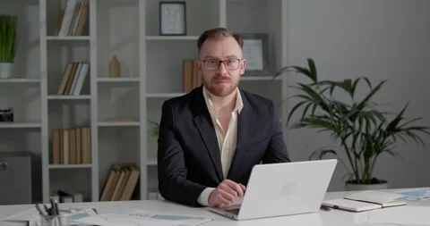 Businessman using laptop, typing on keyboard and looking at the camera. Stock Footage 249181349