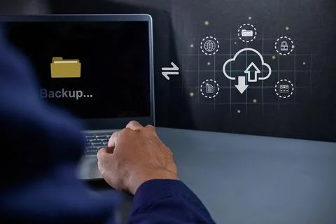 Businessman using a laptop to upload data to cloud storage. Data backup and.. Stock Photos