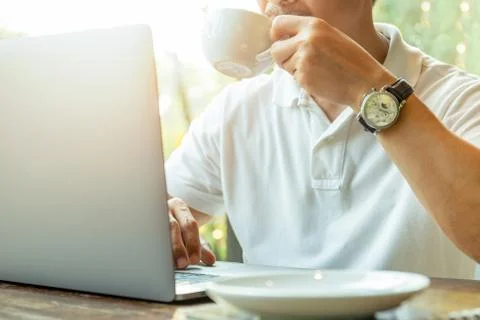Businessman using laptop while having coffee in coffee shop. Stock Photos
