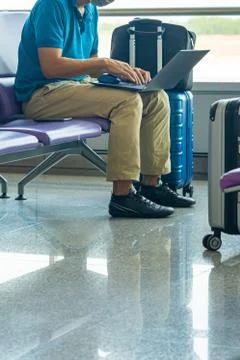 Businessman using laptop while sitting at waiting chair in airport Foto stock