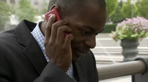 A businessman using a laptop while talking in the cellphone, Stockholm Stock Footage 11288471