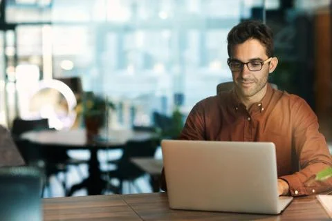 Businessman using a laptop while working late in his office Stock Photos