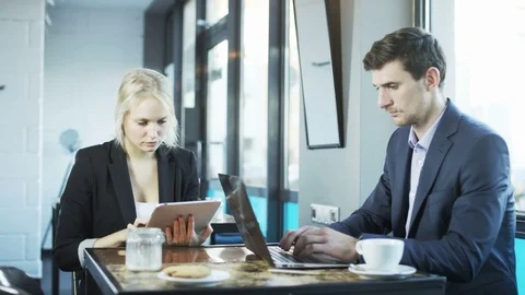 Businessman is Using Laptop, Woman is Using Tablet Stock Footage 71412916