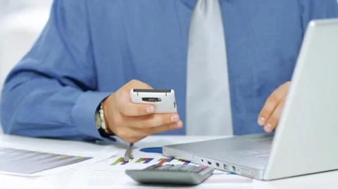 Businessman using mobile phone and laptop computer Stock Footage