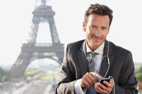 Businessman using a mobile phone with the Eiffel Tower in the background, Paris, 写真素材