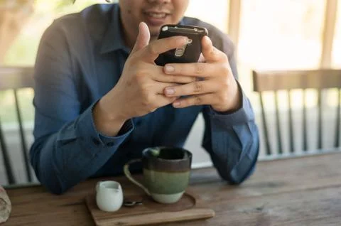 Businessman using mobile phone while sitting in coffee shop Stock Photos