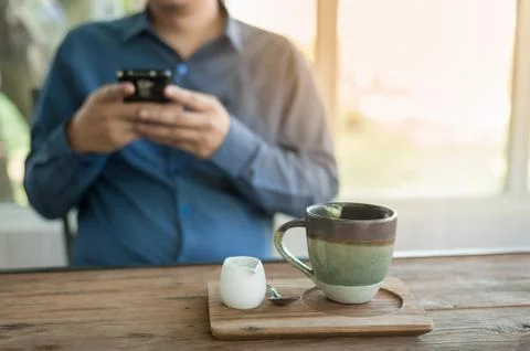 Businessman using mobile phone while sitting in coffee shop Stock Photos