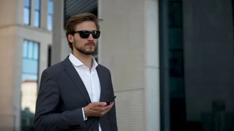 Businessman using mobile phone. Young man talking on Smartphone while walking Stock Footage 211763704