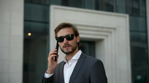 Businessman using mobile phone. Young man talking on Smartphone while walking Stock Footage 211765508