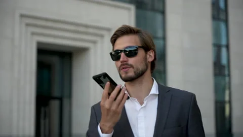 Businessman using mobile phone. Young man talking on Smartphone while walking Stock Footage 211765573