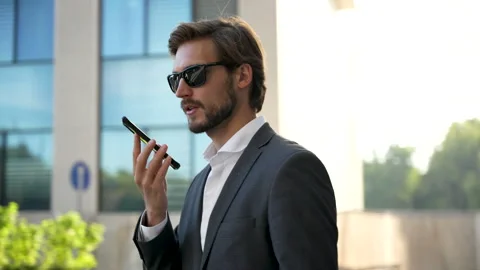 Businessman using mobile phone. Young man talking on Smartphone while walking Stock Footage 211767147