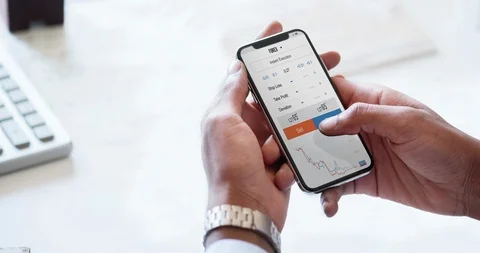 Businessman using an online banking forex app on his smartphone. Parallax Stock-Footage 107827912