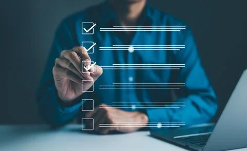 Businessman using pen to tick correct sign mark in checkbox for quality Stock Photos
