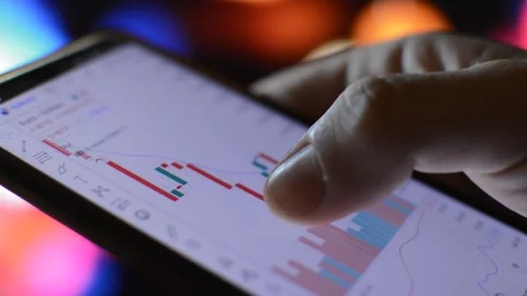 Businessman using phone for trading chart analysis in a night city background. Vídeo Stock 220420129