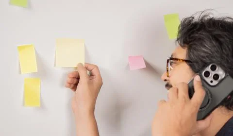 Businessman using phone while planning new project with sticky notes while .. Stockfoto's