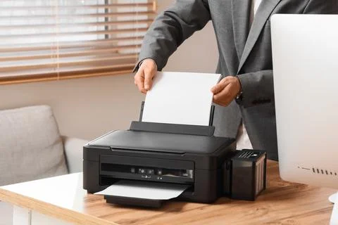 Businessman using printer on desk in office Stock Photos