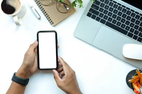 Businessman using smart phone while sitting at his office desk. Stock Photos