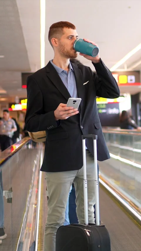 Businessman using smartphone and drinking coffee at airport Stock Footage 302120853