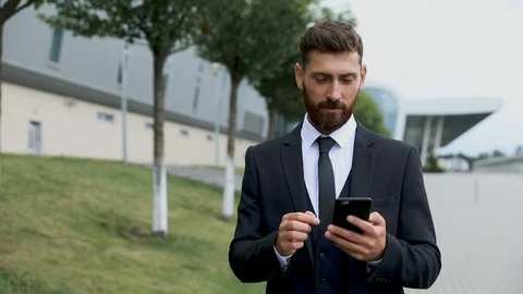 Businessman using smartphone and smiling at airport. Young business executive wi Stock Footage 123473401