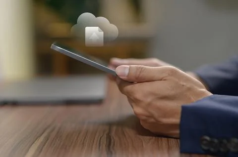Businessman Using Smartphone with Cloud Data Icon in a Modern Workspace Foto stock