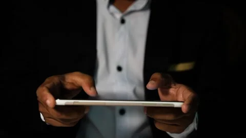 Businessman using smartphone in dark setting Stock Footage 321936931