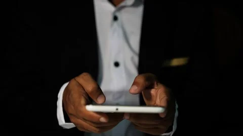 Businessman using smartphone in dark setting, Person in a suit using a smar.. Stock Footage 321936959