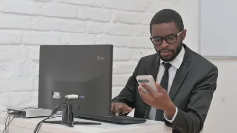 Businessman Using Smartphone with Desktop Computer Video stock 310170446