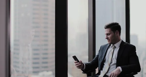 Businessman using smartphone in office skyscraper Stock Footage 99023541