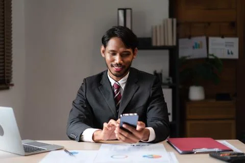 Businessman using smartphone to researching data and analyzing strategy of .. Stock Photos