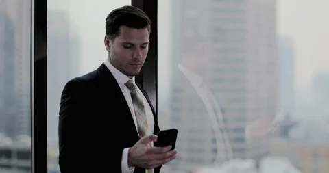 Businessman using smartphone in skyscraper office Stock Footage 99024181