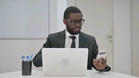 Businessman Using Smartphone While Working on Laptop Stock Footage 310162664
