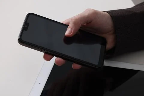 Businessman using smartphone at white table with tablet, closeup. Modern te.. 写真素材