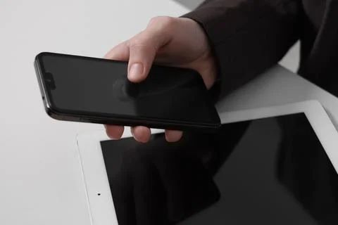 Businessman using smartphone at white table with tablet, closeup. Modern te.. Foto stock