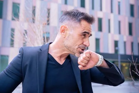 Businessman using smartwatch to communicate in modern urban environment Stock Photos