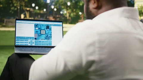 Businessman using software with microchip and circuit board interface Stockbeeldmateriaal 343507321