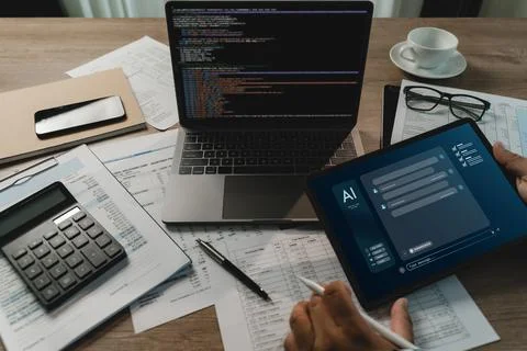 Businessman using a tablet with an AI chatbot interface beside a laptop wit.. 写真素材
