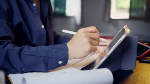 Businessman using a tablet and stylus pen with business performance reports.. Video stock 345942483