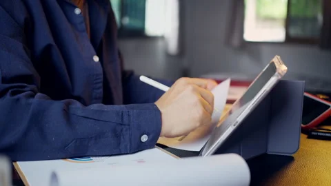 Businessman using a tablet and stylus pen with business performance reports.. Video stock 345942574