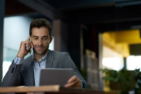 Businessman using a tablet and talking on his cellphone Stock Photos