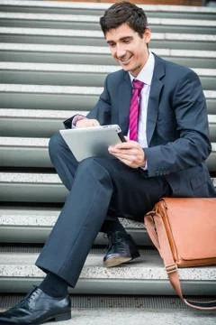 Businessman using a tablet for communication or data storage out Stock Photos