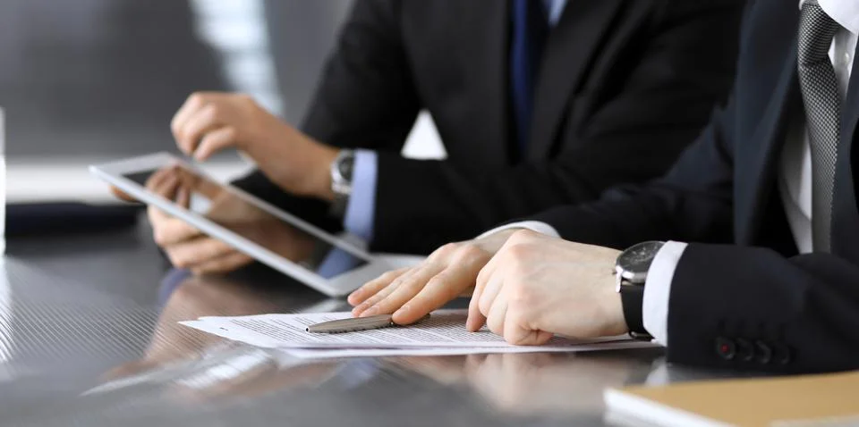 Businessman using tablet computer and work together with his colleague or Stock Photos