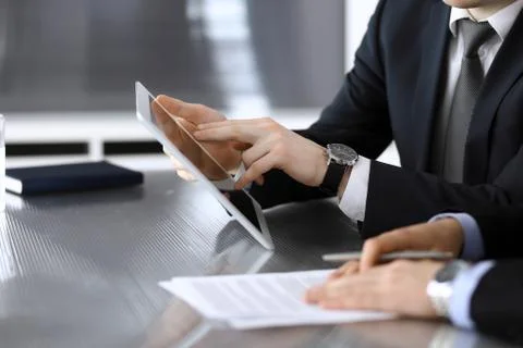 Businessman using tablet computer and work together with his colleague or Stock Photos