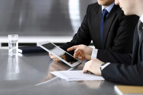 Businessman using tablet computer and work together with his colleague or Stock Photos
