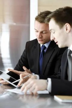 Businessman using tablet computer and work together with his colleague in sunny Stock Photos